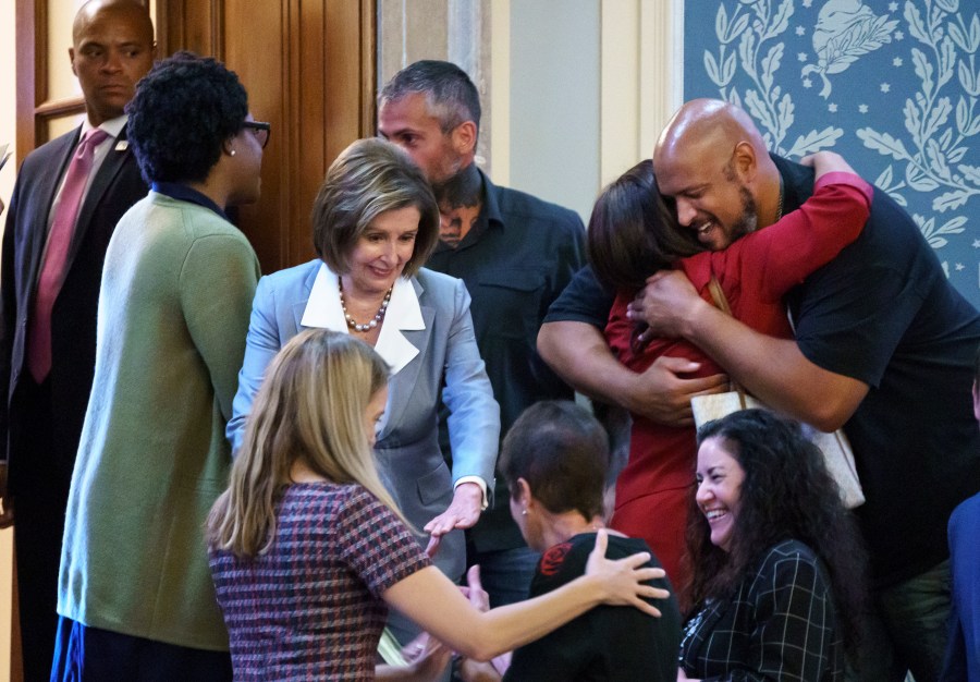 Speaker of the House Nancy Pelosi, D-Calif., center, greets police officers and their family members in the House chamber during the vote to create a select committee to investigate the Jan. 6 Capitol insurrection, at the Capitol in Washington, Wednesday, June 30, 2021. Pelosi reaches out to Gladys Sicknick, bottom center, the mother of Brian Sicknick, a Capitol Police officer who died from injuries sustained during attack. At lower right is Sandra Garza, Brian Sicknick's partner. At upper right, Capitol Police Officer Harry Dunn, who faced the rioters, smiles as he is hugged by Rep. Norma Torres, D-Calif. Metropolitan Police Officer Michael Fanone stands behind Pelosi. (AP Photo/J. Scott Applewhite)