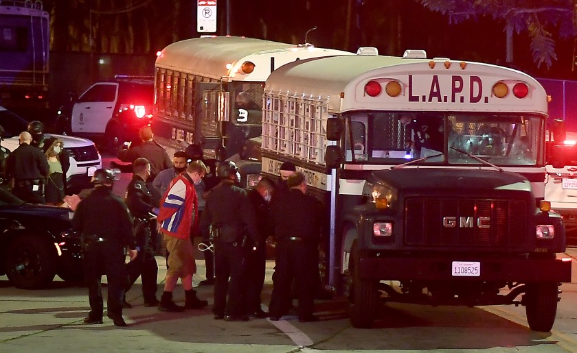 Protesters board a Los Angeles Police Department bus after being arrested in Echo Park in March 2021. (Wally Skalij / Los Angeles Times)