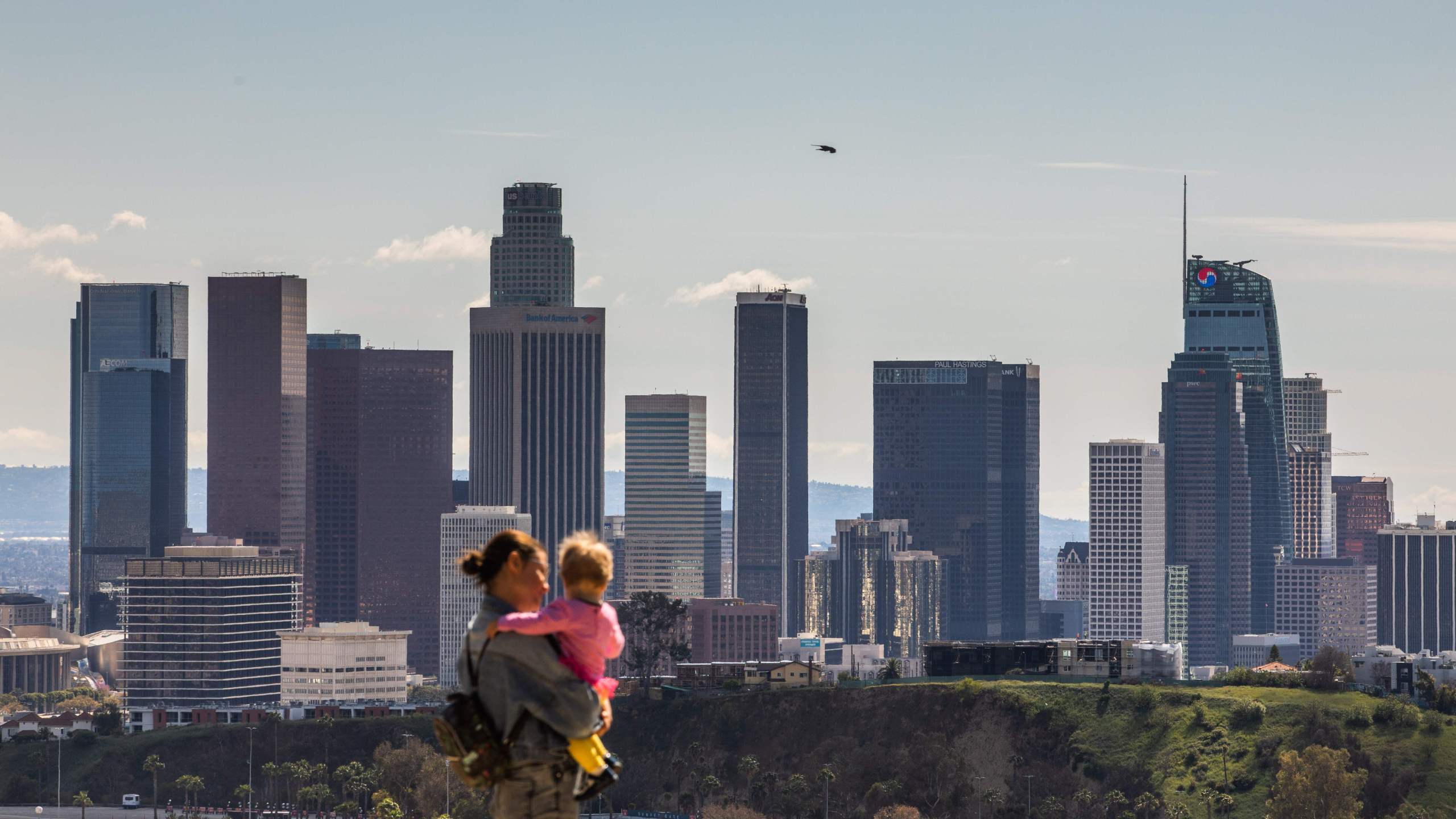 A woman and child look at the Downtown Los Angeles skyline from Elysian Park in Los Angeles on March 21, 2020. (APU GOMES/AFP via Getty Images)