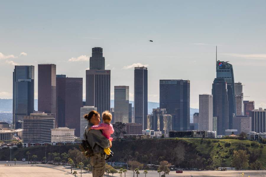 A woman and child look at the Downtown Los Angeles skyline from Elysian Park in Los Angeles on March 21, 2020. (APU GOMES/AFP via Getty Images)