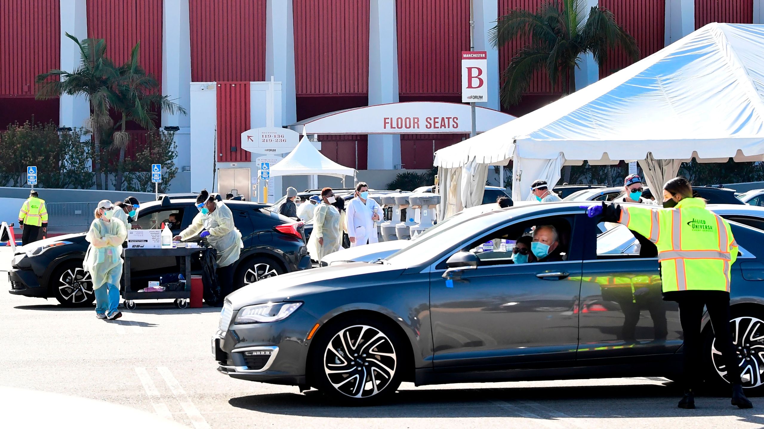 People pull up in their vehicles for COVID-19 vaccines in the parking lot of The Forum in Inglewood on Jan. 19, 2021. (Frederic J. Brown / AFP / Getty Images)