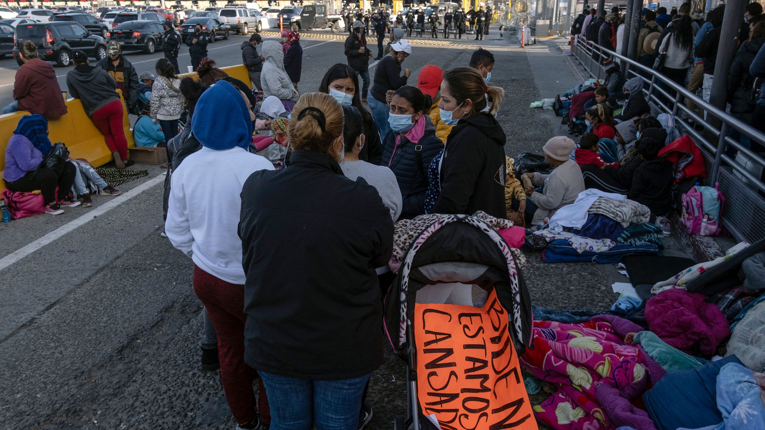 Migrants and asylum seekers are seen after spending the night in one of the car lanes off the San Ysidro Crossing Port on the Mexican side of the US_Mexico border in Tijuana, Baja California state, Mexico on April 24, 2021. (Guillermo Arias / AFP via Getty Images)