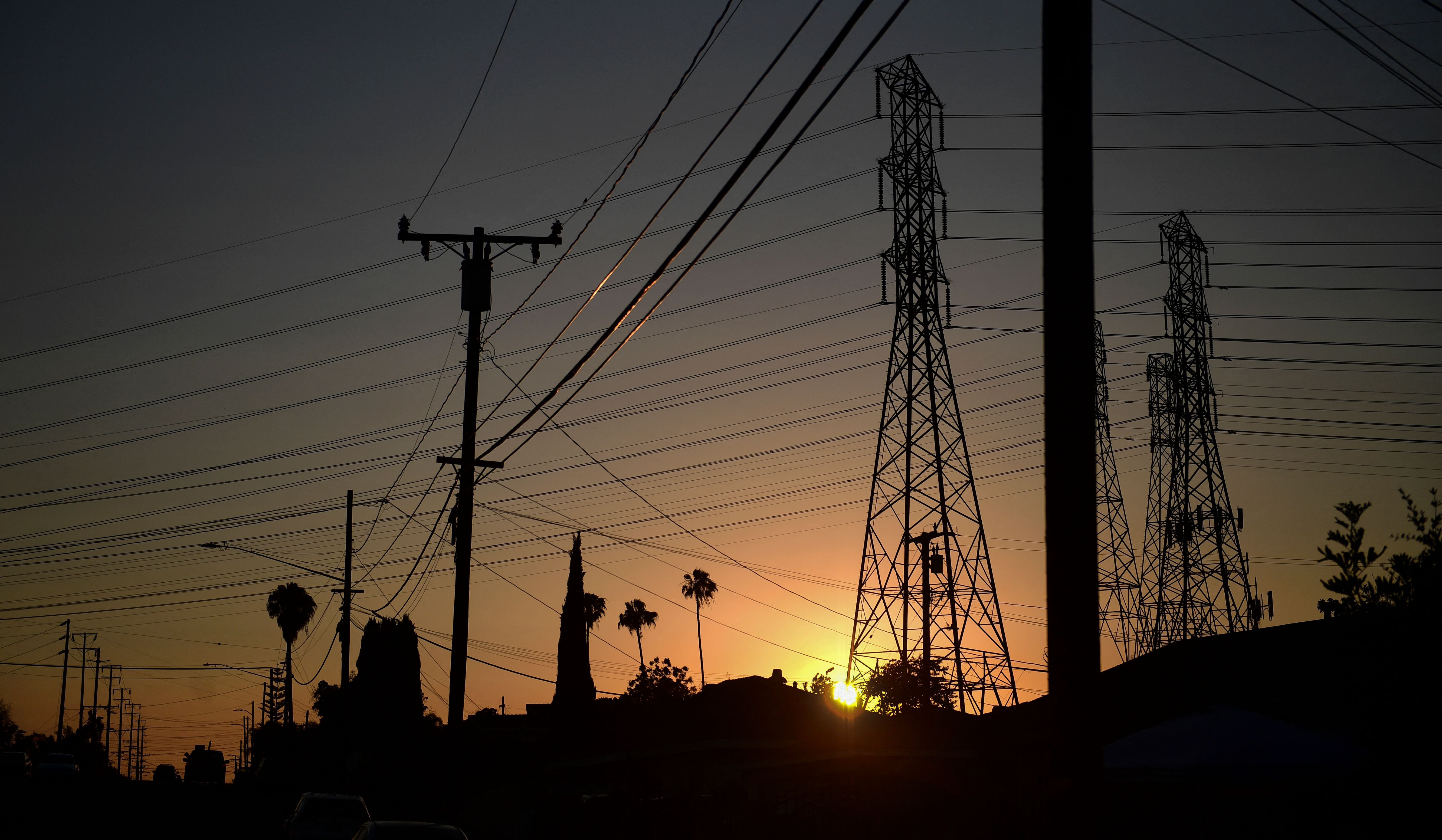 The sun sets behind power lines in Rosemead, on June 14, 2021. (FREDERIC J. BROWN/AFP via Getty Images)