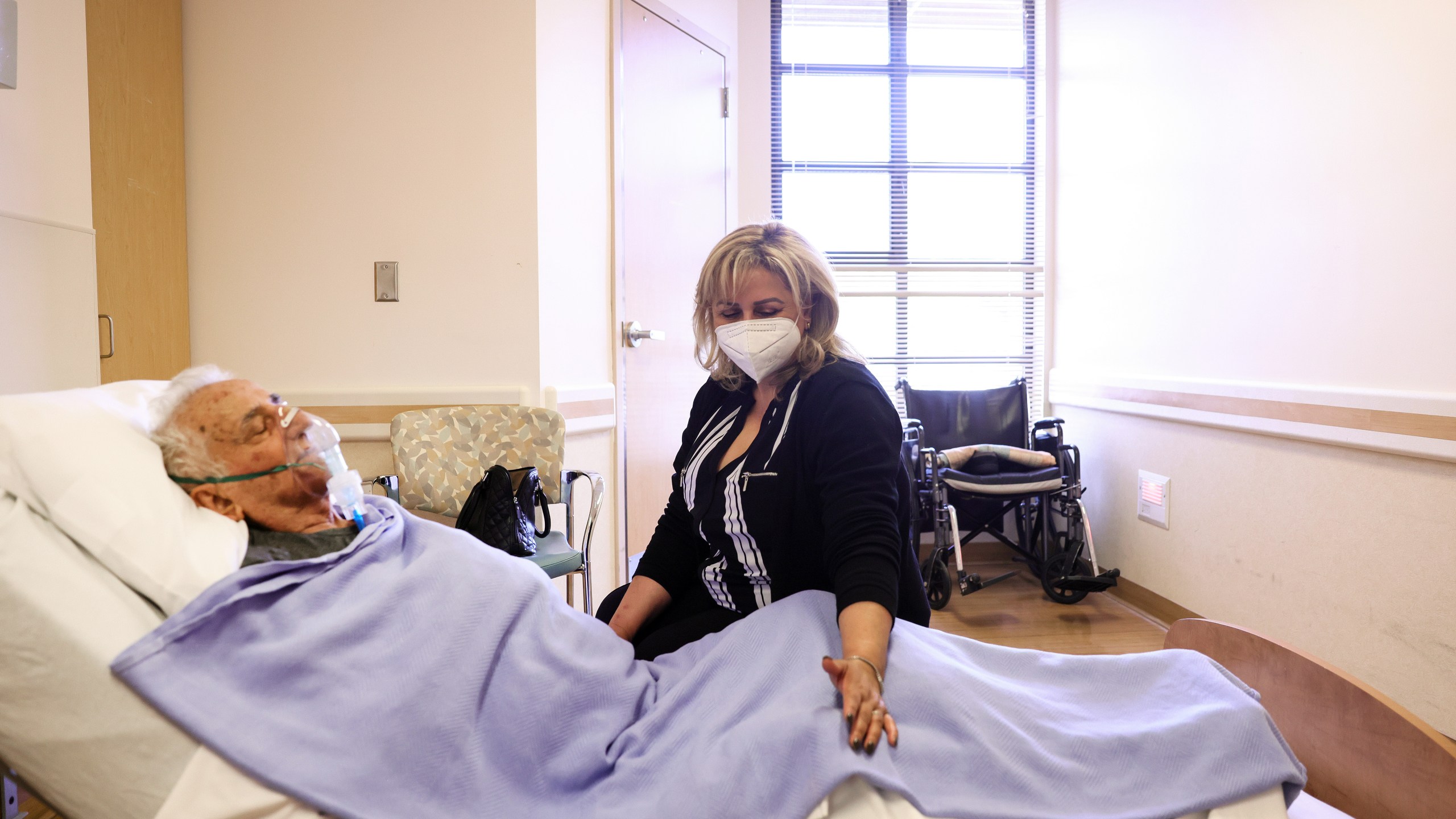 Resident Hanna Nasi is visited by daughter Surab Nasrallah on the first day of in-room family member visits at the Ararat Nursing Facility in the Mission Hills neighborhood on March 24, 2021 in Los Angeles, California. (Mario Tama/Getty Images)