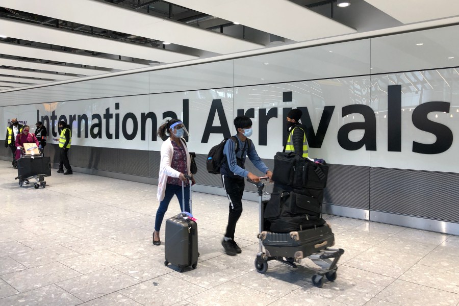 Passengers are escorted through the arrivals area of terminal 5 towards coaches destined for quarantine hotels, after landing at Heathrow airport on April 23, 2021 in London, England. (Leon Neal/Getty Images)