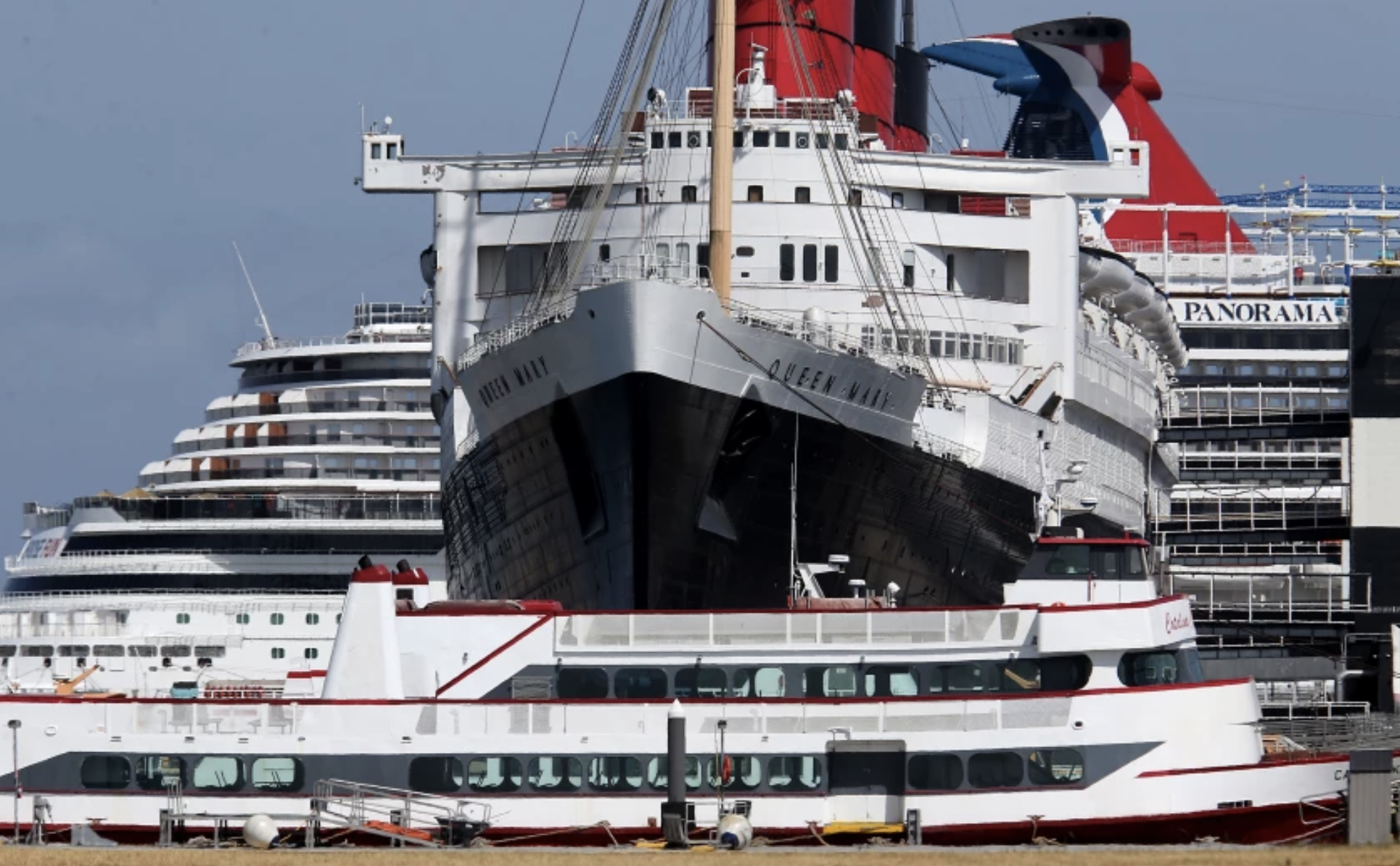 The Queen Mary is berthed between tour boats and a cruise ship in the Port of Long Beach. A new report shows the ship is in urgent need of repairs.(Luis Sinco / Los Angeles Times)