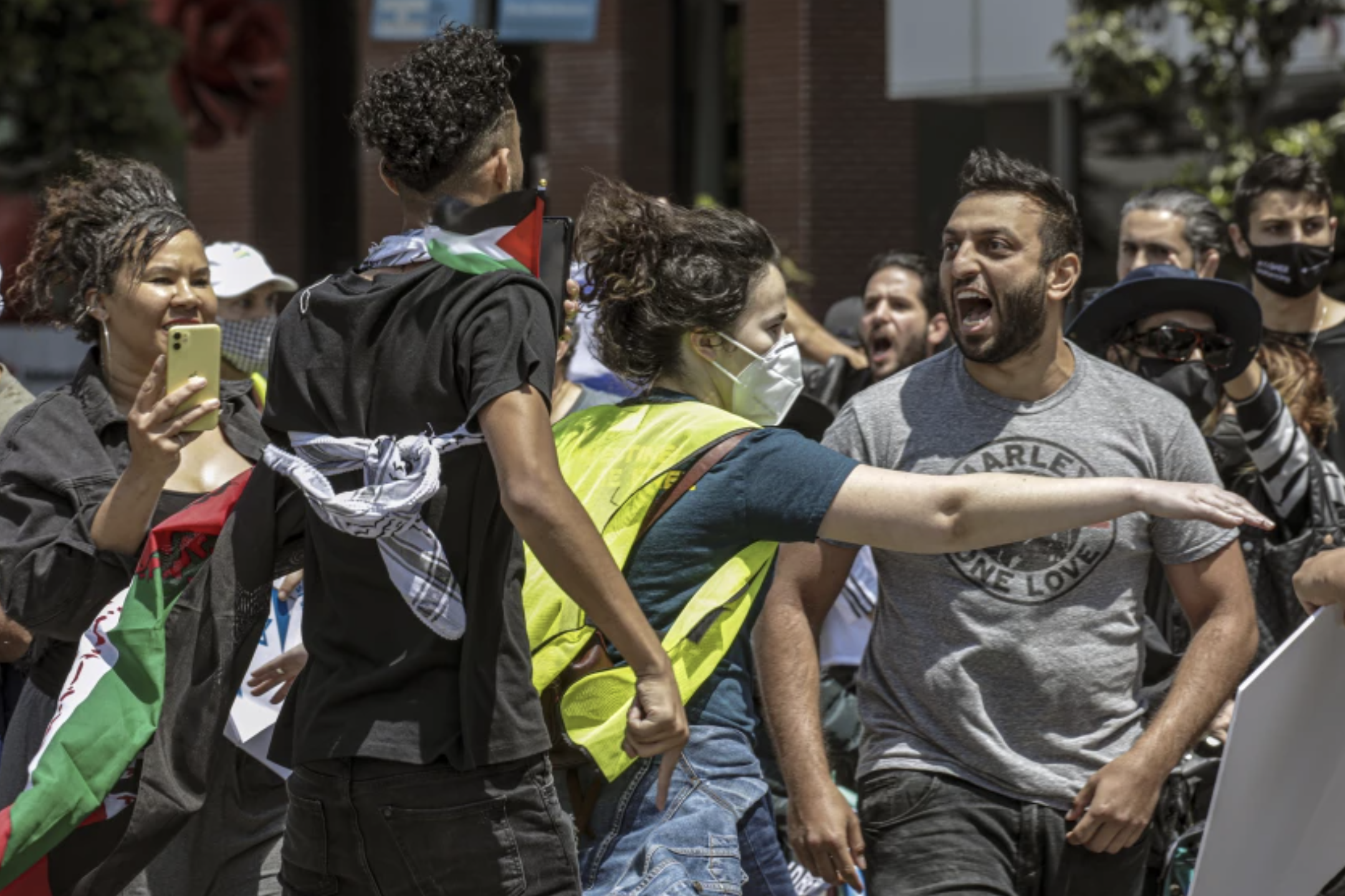 A rally organizer, center, separates a Palestinian supporter, left, and an Israeli supporter, right, at a rally in Los Angeles in May 2021.(Irfan Khan / Los Angeles Times)