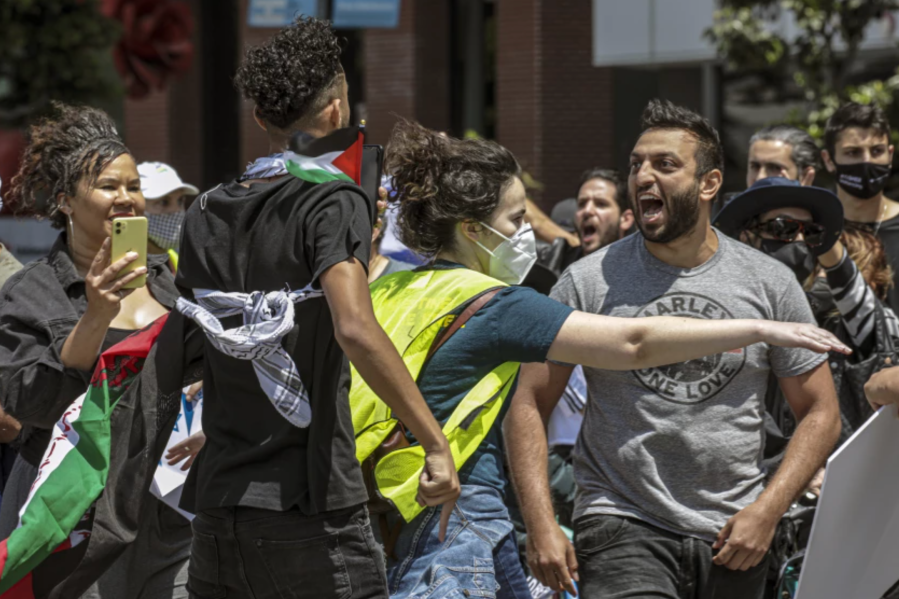 A rally organizer, center, separates a Palestinian supporter, left, and an Israeli supporter, right, at a rally in Los Angeles in May 2021.(Irfan Khan / Los Angeles Times)