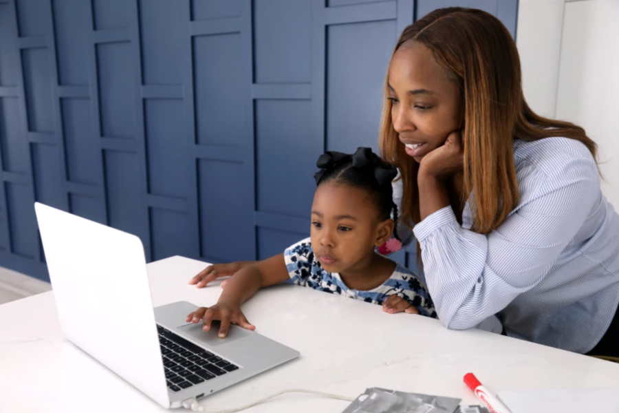 Cali Corbin, 5, a kindergartner at Westwood Charter School, works on a mathematical exercise under the watchful eye of her mother Renee Bailey in their home in Los Angeles on April 9. (Genaro Molina / Los Angeles Times)