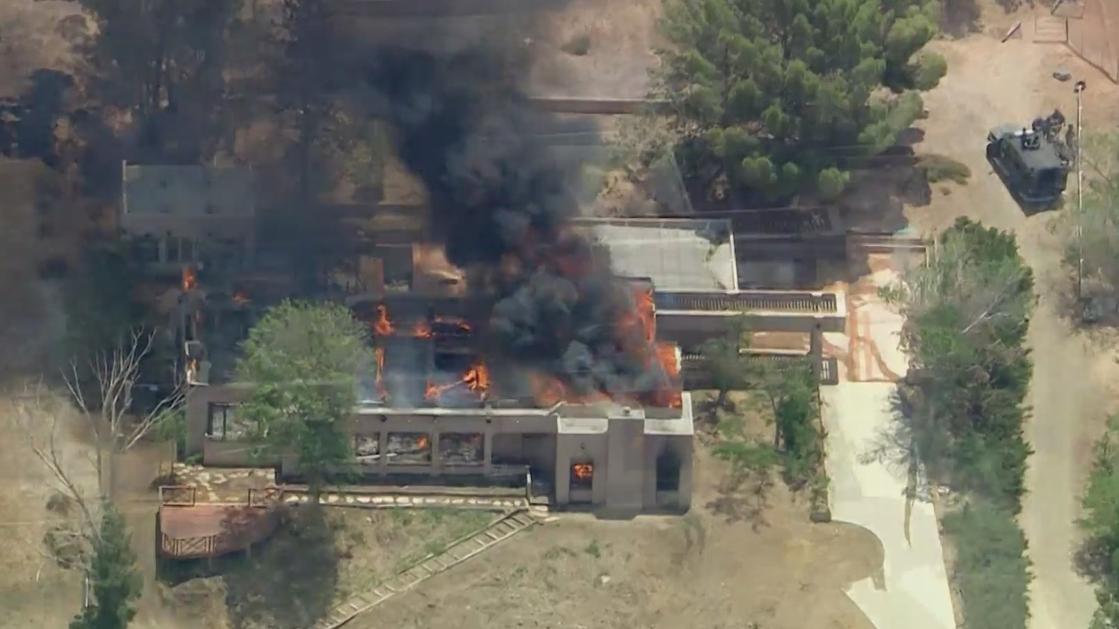 A home burns in Acton after an off-duty firefighter accused of shooting two colleagues, one fatally, was found dead there on June 1, 2021. (KTLA)