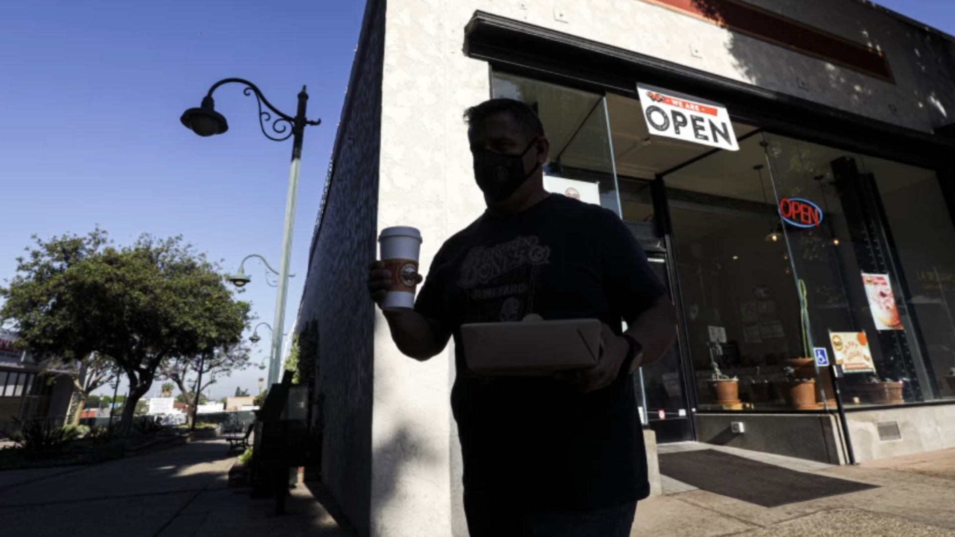 Businesses are headed for full reopening on June 15, when California drops pandemic restrictions. Economists say a consumer-spending boom will drive economic recovery. Above, David Fernandez carries his breakfast from La Monarca Bakery in Whittier last year.(Irfan Khan / Los Angeles Times)