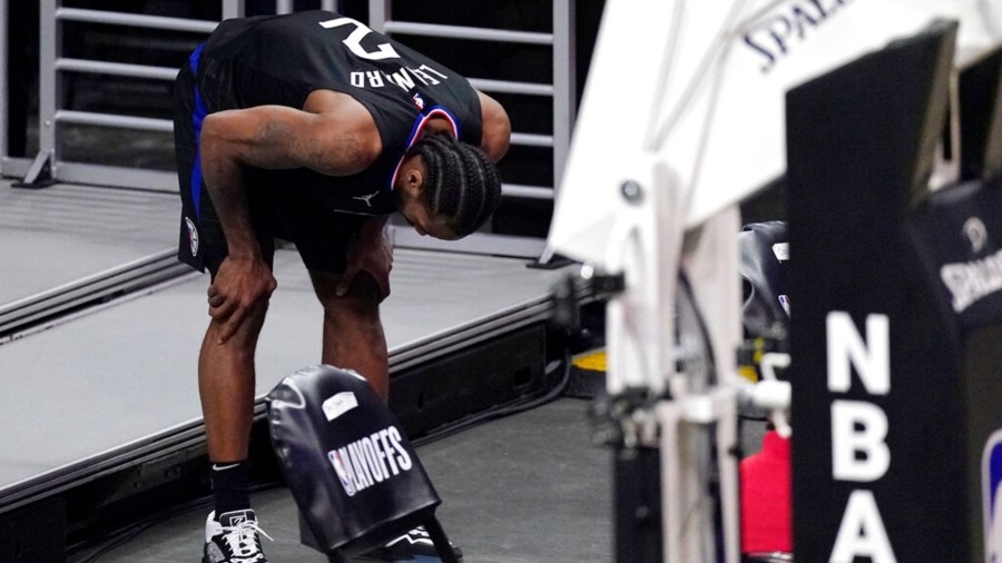 Los Angeles Clippers forward Kawhi Leonard holds his knee after stepping awkwardly during the second half in Game 4 of a second-round NBA basketball playoff series against the Utah Jazz in Los Angeles on June 14, 2021. (Mark J. Terrill / Associated Press)