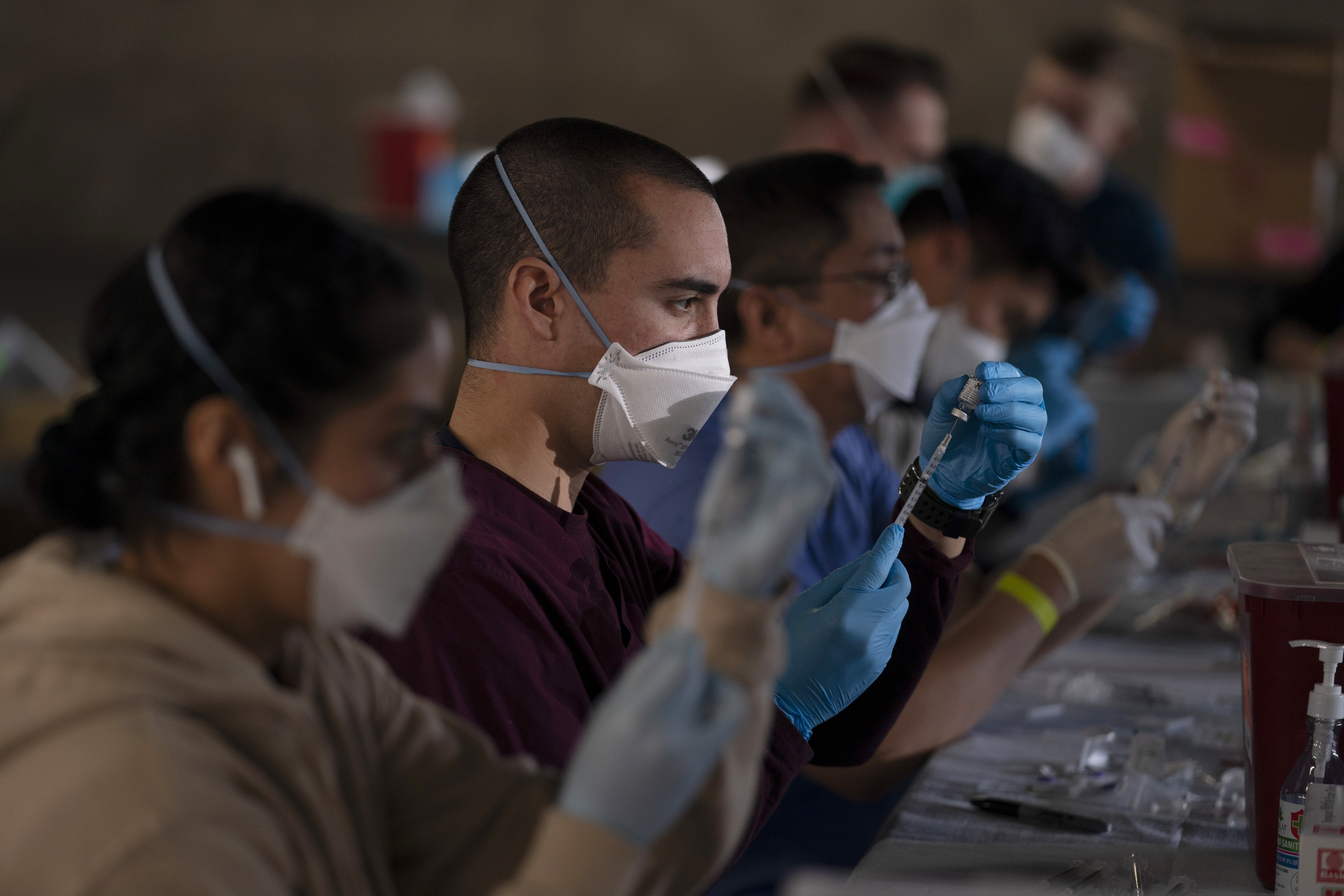 Members of the California National Guard fill syringes with Pfizer's COVID-19 vaccine at a site in Long Beach on March 5, 2021. (Jae C. Hong / Associated Press)