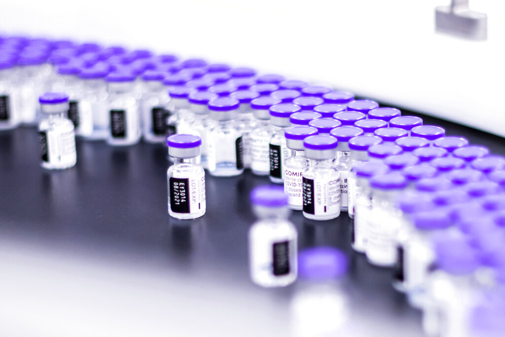 In this March 2021 photo provided by Pfizer, vials of the Pfizer-BioNTech COVID-19 vaccine are prepared for packaging at the company’s facility in Puurs, Belgium. (Pfizer via AP)