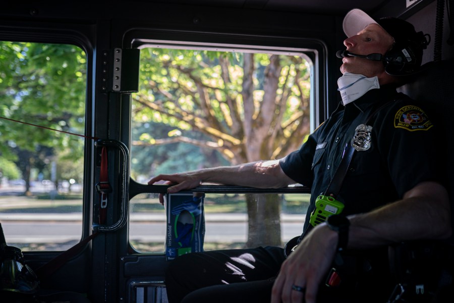 Salem Fire Department paramedic Justin Jones tries to stay cool after responding to a heat exposure call during a heat wave, Saturday, June 26, 2021, in Salem, Ore. (AP Photo/Nathan Howard)