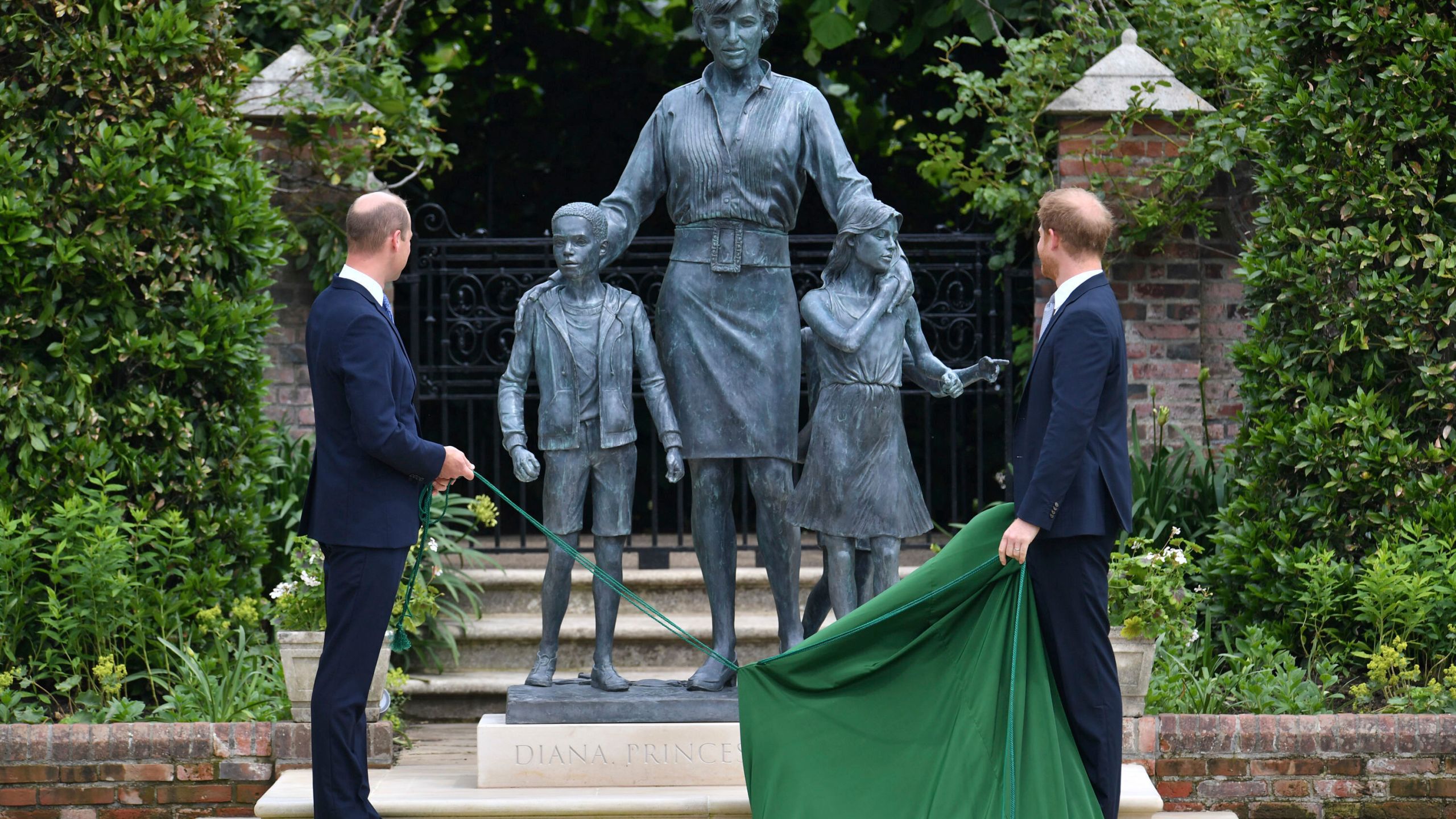 Britain's Prince William, left and Prince Harry unveil a statue they commissioned of their mother Princess Diana, on what woud have been her 60th birthday, in the Sunken Garden at Kensington Palace, London, Thursday July 1, 2021. (Dominic Lipinski /Pool Photo via AP)