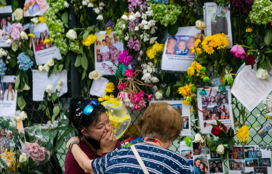 In this June 29, 2021, file photo, mourners visit a makeshift memorial near the site of the collapsed condominium in Surfside, Fla. While hundreds of rescuers search desperately for survivors within the rubble of the collapsed condominium, a smaller cadre of mental health counselors are also deploying to help families and other loved ones cope with the tragedy. (Matias J. Ocner/Miami Herald via AP, File)