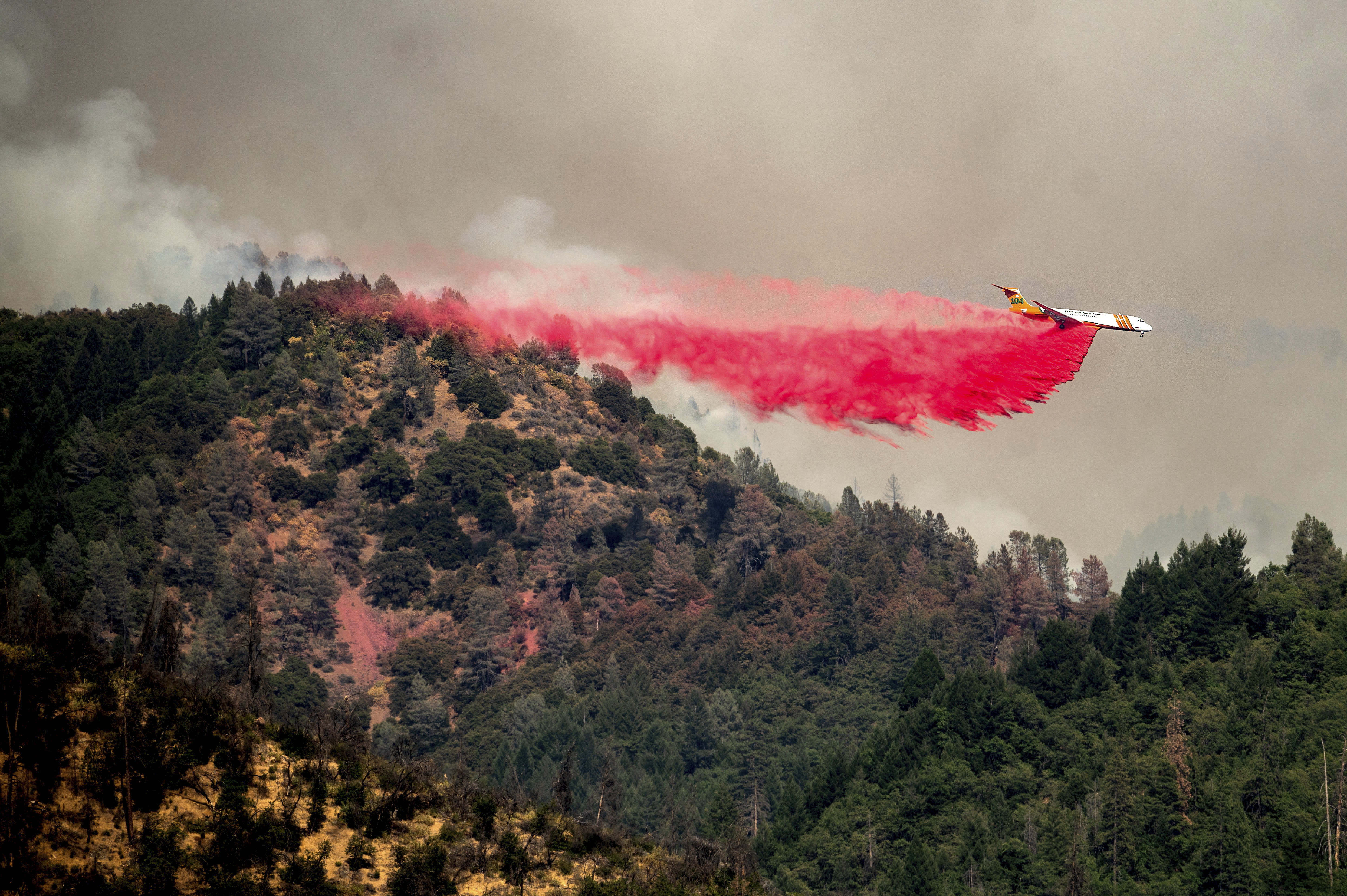 An air tanker drops retardant while trying to stop the Salt Fire from spreading near Lakehead in unincorporated Shasta County, Calif., on July 2, 2021. (Noah Berger / Associated Press)