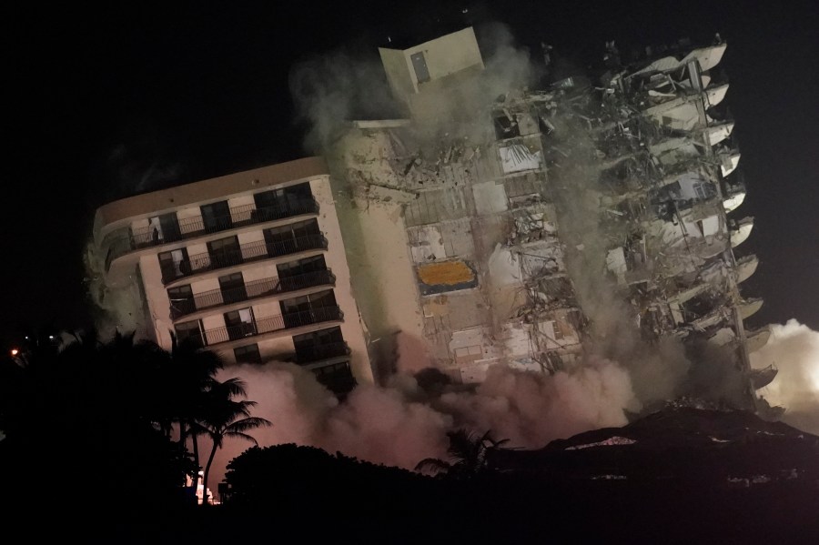 The damaged remaining structure at the Champlain Towers South condo building collapses in a controlled demolition, Sunday, July 4, 2021, in Surfside, Fla. The decision to demolish the Surfside building came after concerns mounted that the damaged structure was at risk of falling, endangering the crews below and preventing them from operating in some areas.(AP Photo/Lynne Sladky)