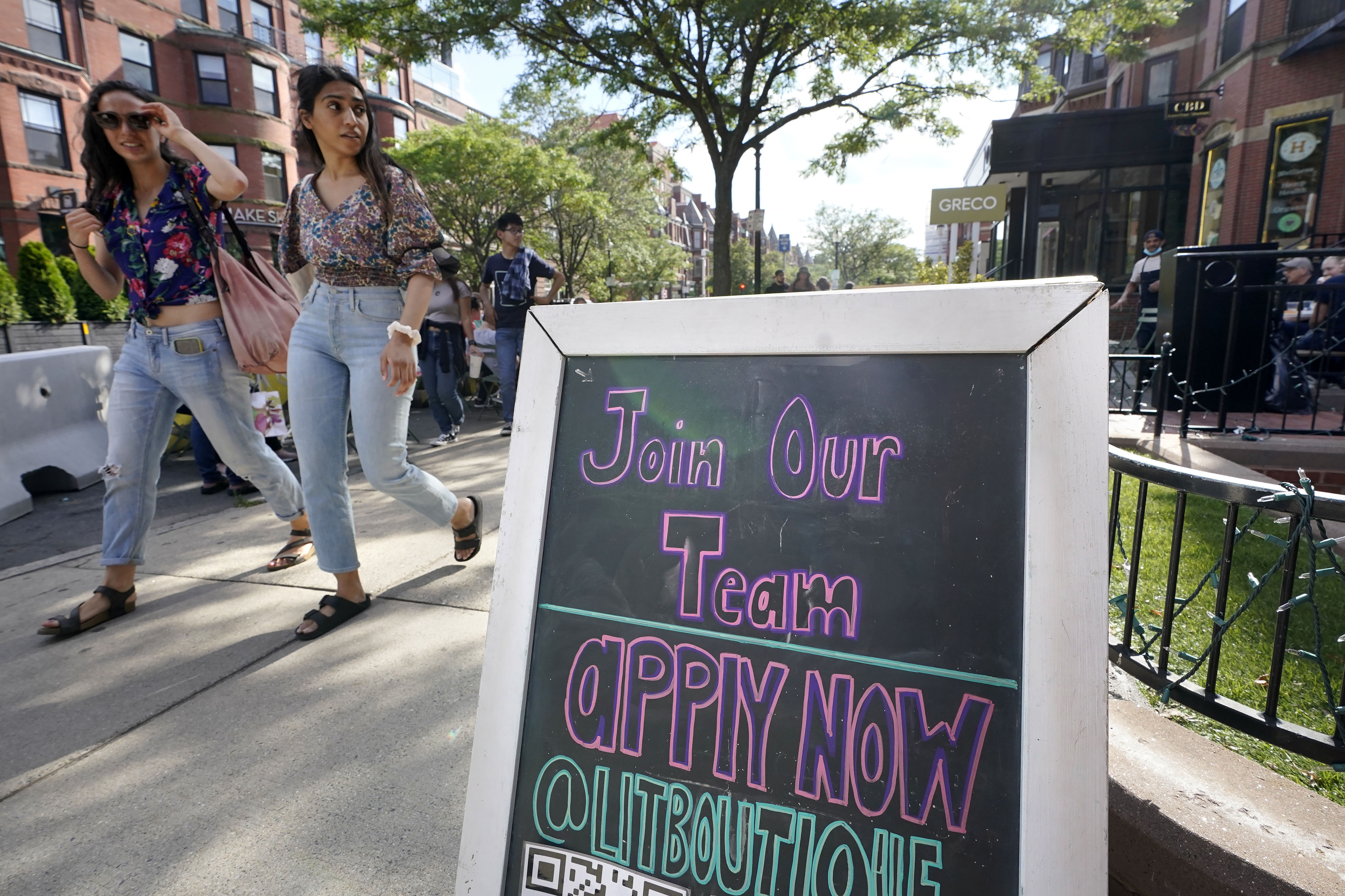 Pedestrians walk past a sign inviting people to apply for employment at a shop in Boston's fashionable Newbury Street neighborhood, Monday, July 5, 2021. As the U.S. economy bounds back with unexpected speed from the pandemic recession and customer demand intensifies, high school-age kids are filling jobs that older workers can’t — or won’t. (AP Photo/Steven Senne)