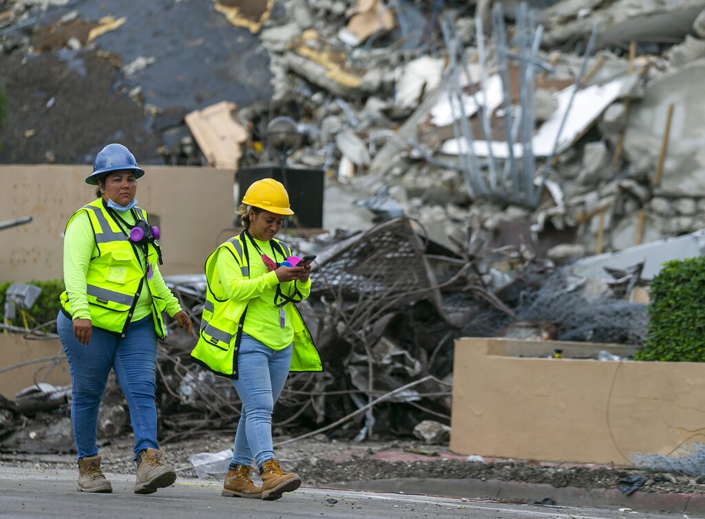 A workers make her way past the rubble and debris of the Champlain Towers South condo in Surfside, Florida on Tuesday, July 6, 2021. (Matias J. Ocner/Miami Herald via AP)