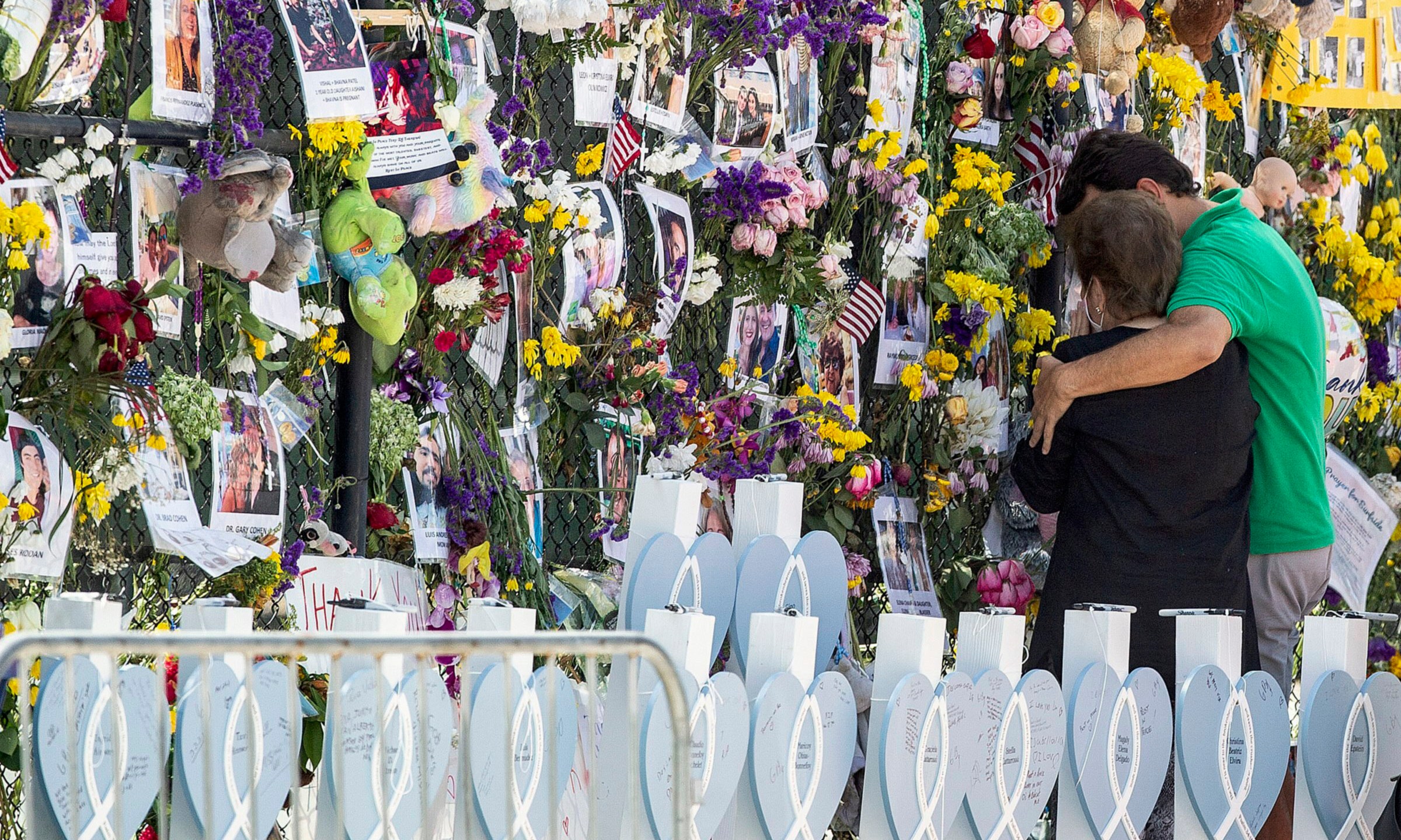 In this Thursday July 8, 2021, file photo, people mourn at the memorial wall for the victims of the Champlain Towers South collapse, in Surfside, Fla. Families waiting in agony for news on relatives who were in the Florida condo building when it collapsed are turning to each other for support. (Pedro Portal/Miami Herald via AP, File)