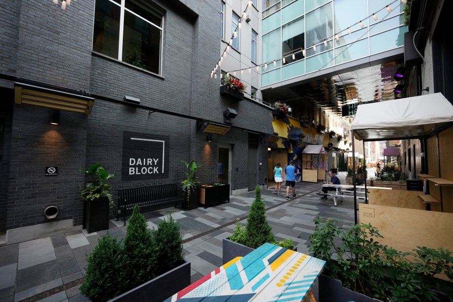 Pedestrians move through the alleyway in the Dairy Block and past the outside of the Maven Hotel Sunday, July 11, 2021, in lower downtown Denver. (AP Photo/David Zalubowski)