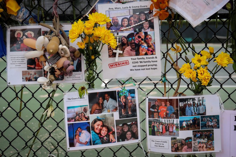 In this July 6, 2021, file photo, a memorial for the Guara family is posted on a fence near the Champlain Towers South, in Surfside, Fla. Recovery crews at the Florida condominium collapse are cataloging all personal possessions found in the rubble in hopes of returning them to families of the dead or survivors. (Carl Juste/Miami Herald via AP, File)