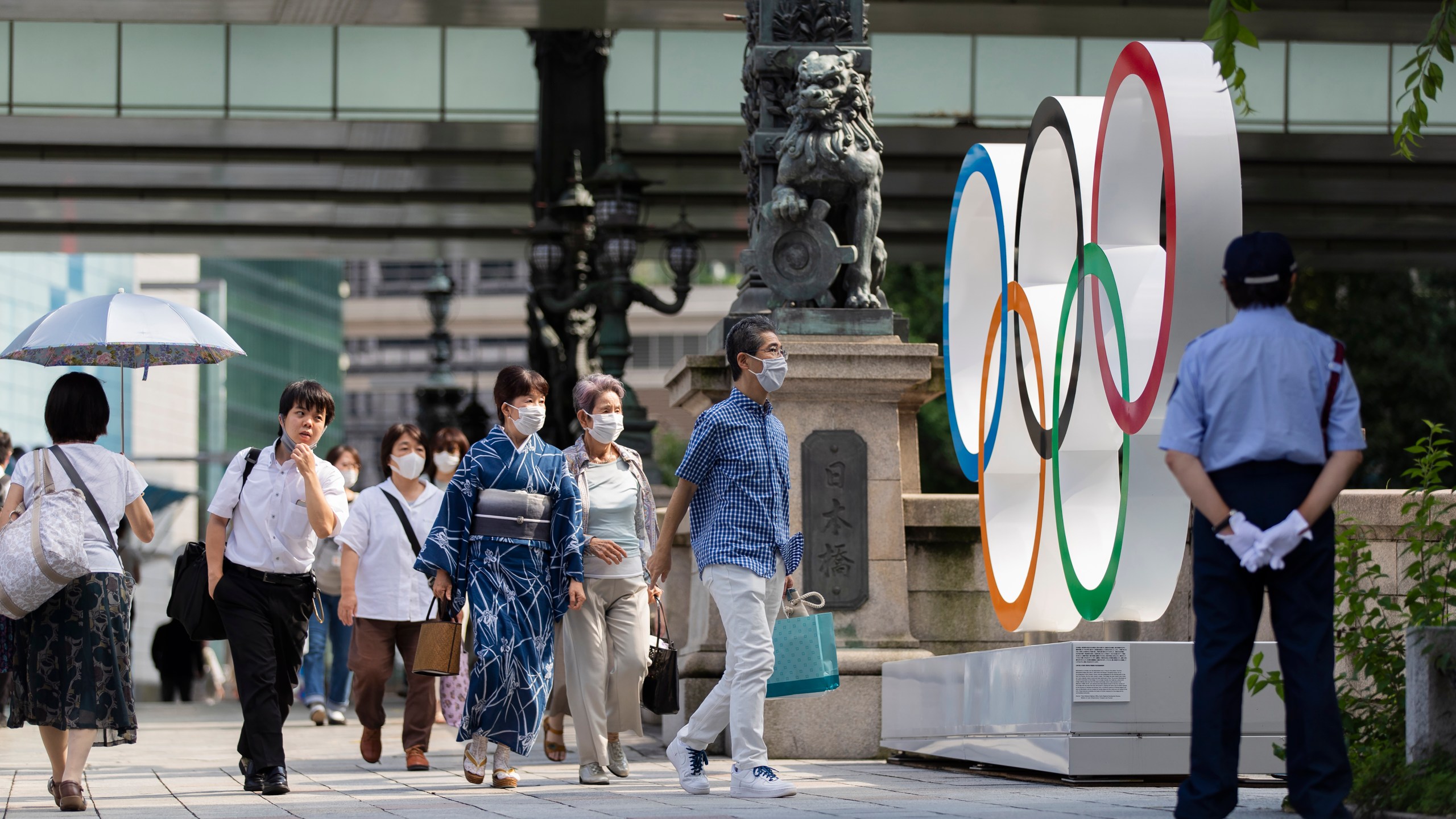 People walk by the Olympic rings installed by the Nippon Bashi bridge in Tokyo on Thursday, July 15, 2021. (Hiro Komae/Associated Press)