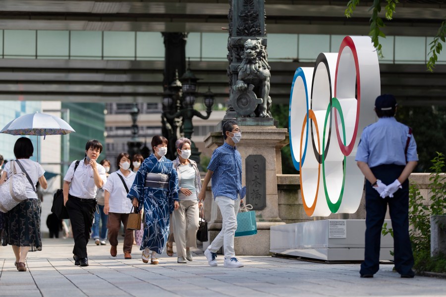 People walk by the Olympic rings installed by the Nippon Bashi bridge in Tokyo on Thursday, July 15, 2021. (Hiro Komae/Associated Press)