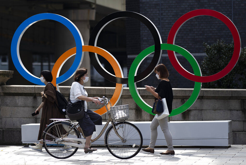 People walk by the Olympic rings installed by the Nippon Bashi bridge in Tokyo on Thursday, July 15, 2021. (AP Photo/Hiro Komae)