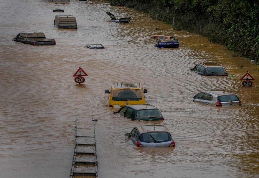 Cars show up as the flood sinks on a road in Erftstadt, Germany, Saturday, July 17, 2021. Due to strong rain falls the small Erft river went over the banks causing massive damages. (AP Photo/Michael Probst)