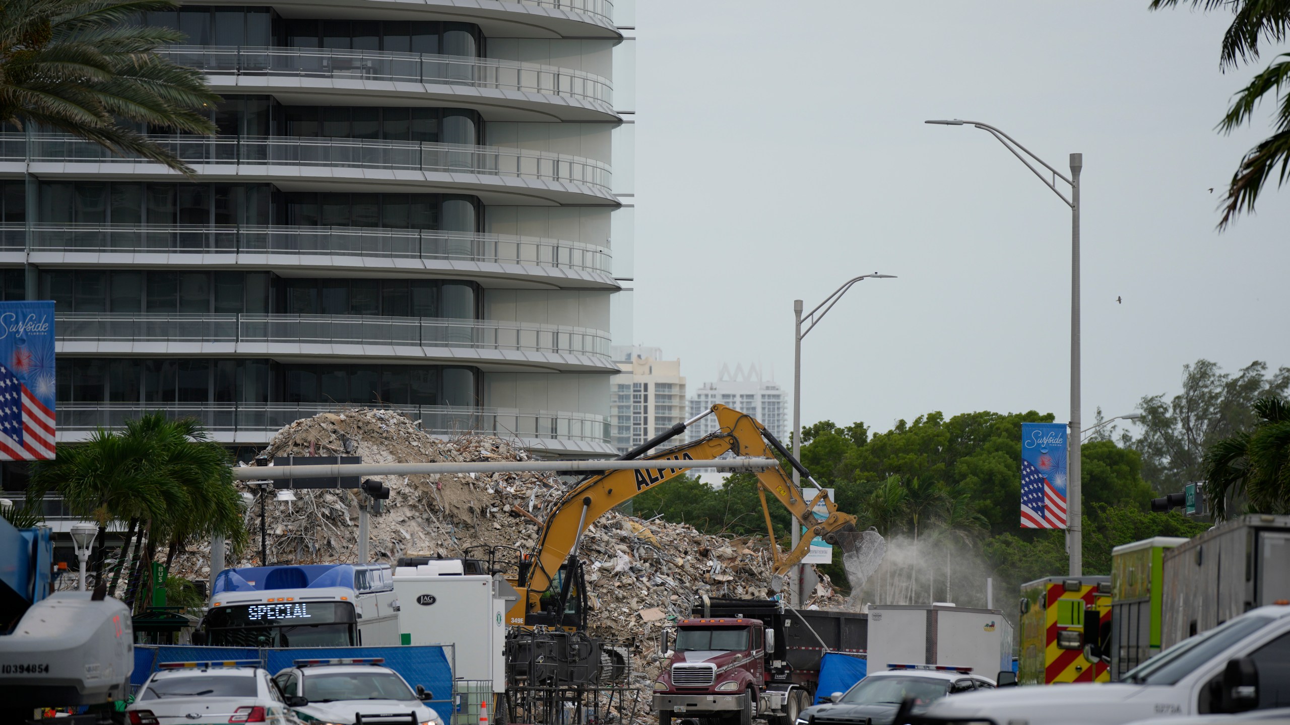 In this July 12, 2021 file photo, an excavator removes the rubble of the demolished section of the Champlain Towers South building, as recovery work continues at the site of the partially collapsed condo building, in Surfside, Fla. Another victim has been identified in the collapse of a 12-story Florida condominium. The Miami-Dade Police Department said in a news release Saturday, July 17, that Theresa Velasquez, 36, was a confirmed fatality in the June 24 collapse of the Champlain Towers South condo. (AP Photo/Rebecca Blackwell, File)