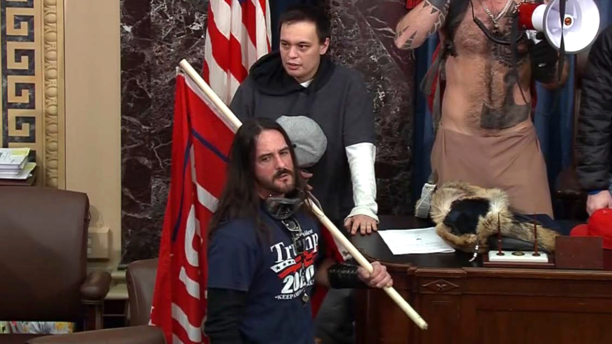 In this file image from U.S. Capitol Police video, Paul Allard Hodgkins, 38, of Tampa, Fla., front, stands in the well on the floor of the U.S. Senate on Jan. 6, 2021, at the Capitol in Washington. (U.S. Capitol Police via AP, File)