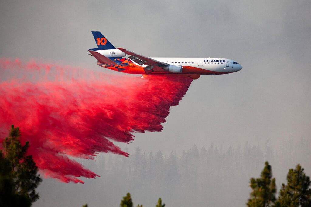 In this photo provided by the Bootleg Fire Incident Command, a DC-10 tanker drops retardant over the Bootleg Fire in southern Oregon, Thursday, July 15, 2021. (Bootleg Fire Incident Command via AP)