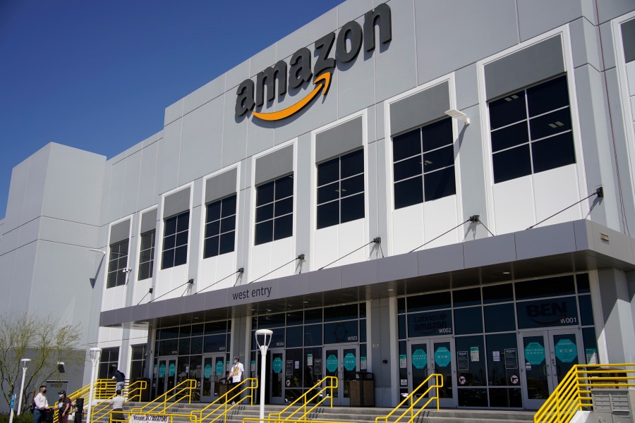 A worker walks out of an Amazon Fulfillment Center, Wednesday, March 31, 2021, in North Las Vegas. Amazon said it will stop testing its workers for COVID-19 at its warehouses at the end of July, citing the availability of vaccines and free testing. (AP Photo/John Locher)