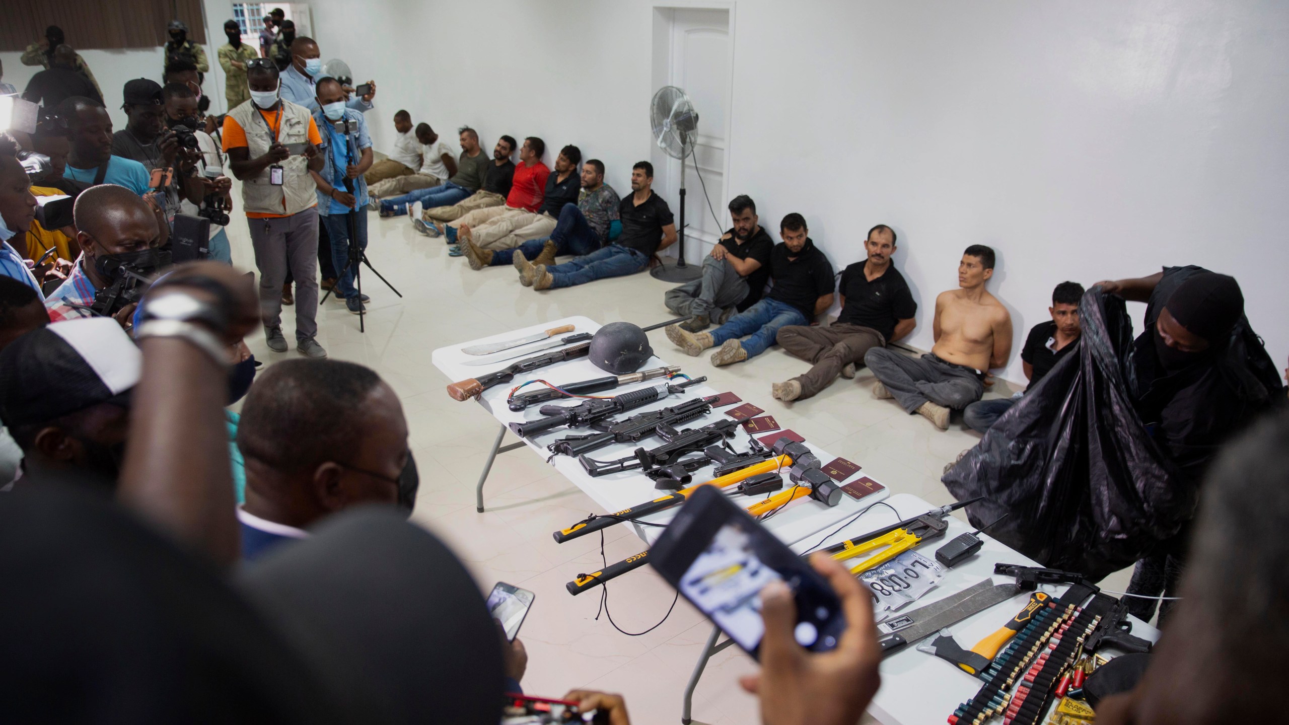 In this July 8, 2021 file photo, suspects in the assassination of Haiti's President Jovenel Moise are shown to the media, along with the weapons and equipment they allegedly used in the attack, at police headquarters in Port-au-Prince. (Jean Marc Hervé Abélard/Associated Press)