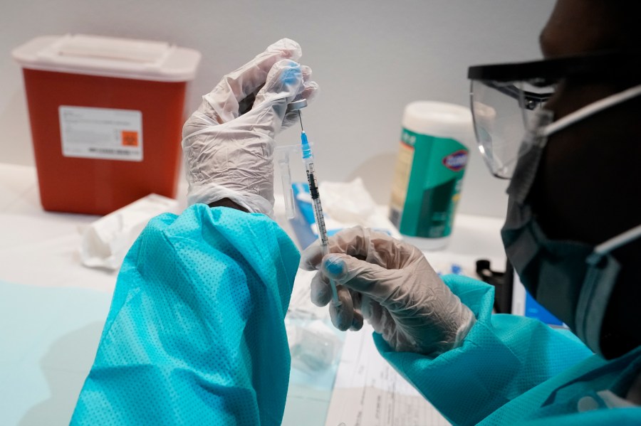 In this July 22, 2021 file photo, a health care worker fills a syringe with the Pfizer COVID-19 vaccine at the American Museum of Natural History in New York. (AP Photo/Mary Altaffer)