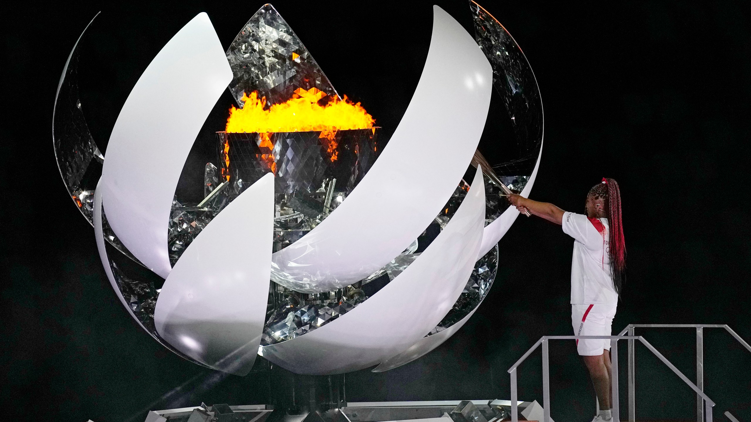 Naomi Osaka lights the Olympic flame during the opening ceremony in the Olympic Stadium at the 2020 Summer Olympics on July 23, 2021, in Tokyo. (David J. Phillip/Associated Press)