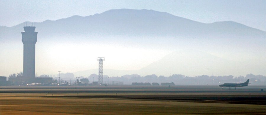 In this Sept. 24, 2014 file photo, smoke hangs over Reno-Tahoe International Airport as a plane takes off in Reno, Nevada. (AP Photo/Martha Irvine, File)