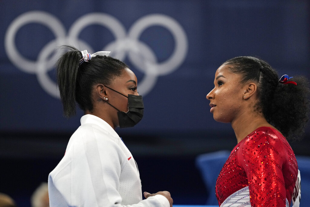 Simone Biles, of the United States, talks to teammate Jordan Chiles prior to the latter's performance on the uneven bars during the artistic gymnastics women's finalat the 2020 Summer Olympics, Tuesday, July 27, 2021, in Tokyo. (AP Photo/Ashley Landis)