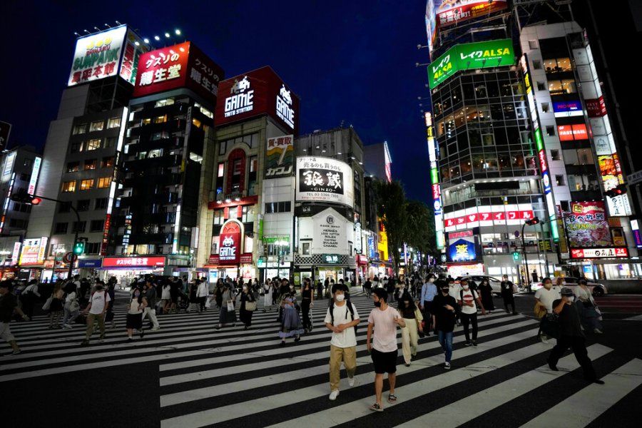 People walk along a pedestrian crossing Friday, July 30, 2021, in Tokyo, as Japanese Prime Minister Yoshihide Suga expanded a coronavirus state of emergency to four more areas in addition to Tokyo following record spikes in infections as the capital hosts the Olympics. (AP Photo/Eugene Hoshiko)