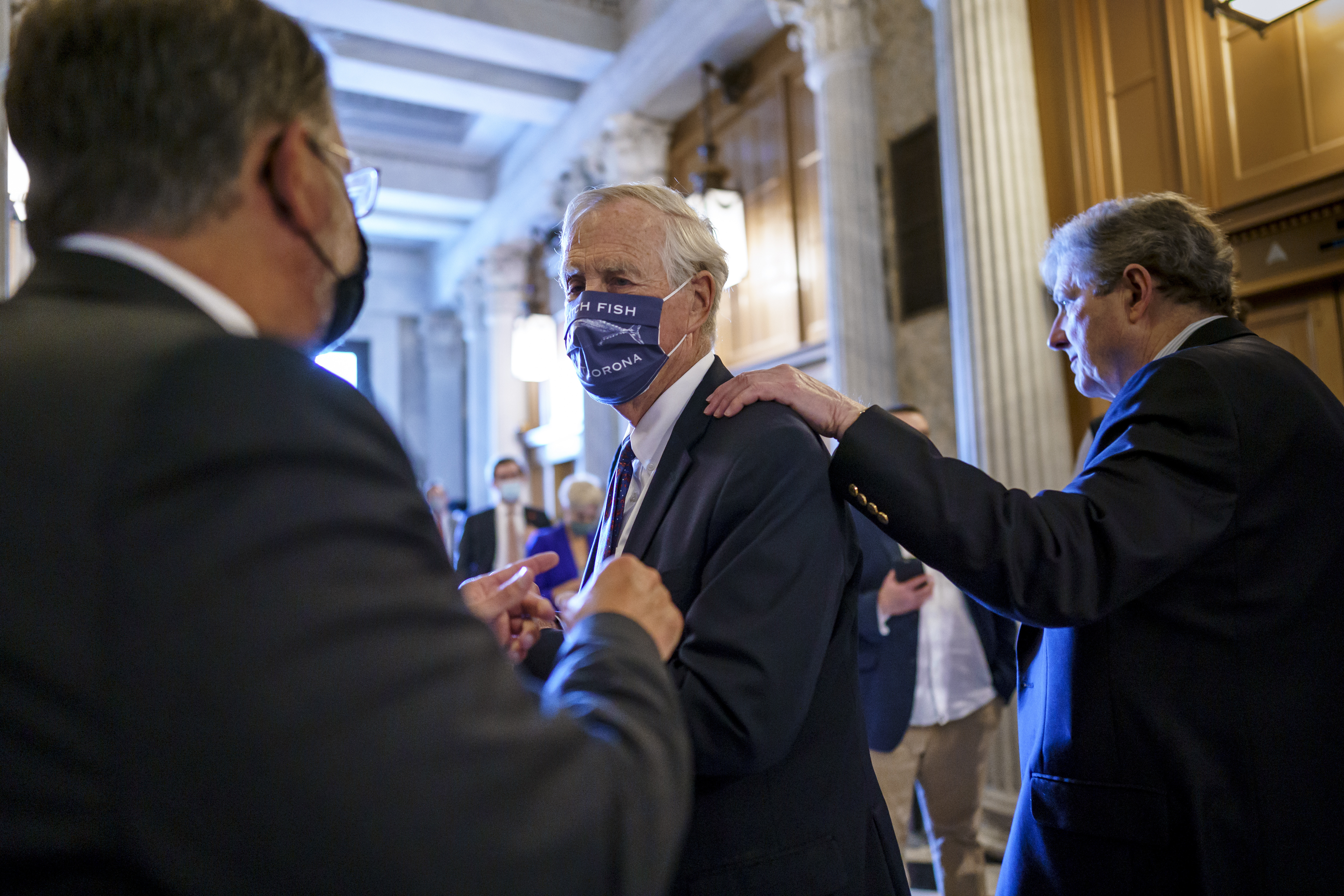 Sen. Angus King, I-Maine, center, speaks with Sen. Gary Peters, D-Mich., left, while Sen. John Kennedy, R-La., walks by at right, as the Senate votes to formally begin debate on a roughly $1 trillion infrastructure plan, a process that could take several days, at the Capitol in Washington, Friday, July 30, 2021. (AP Photo/J. Scott Applewhite)