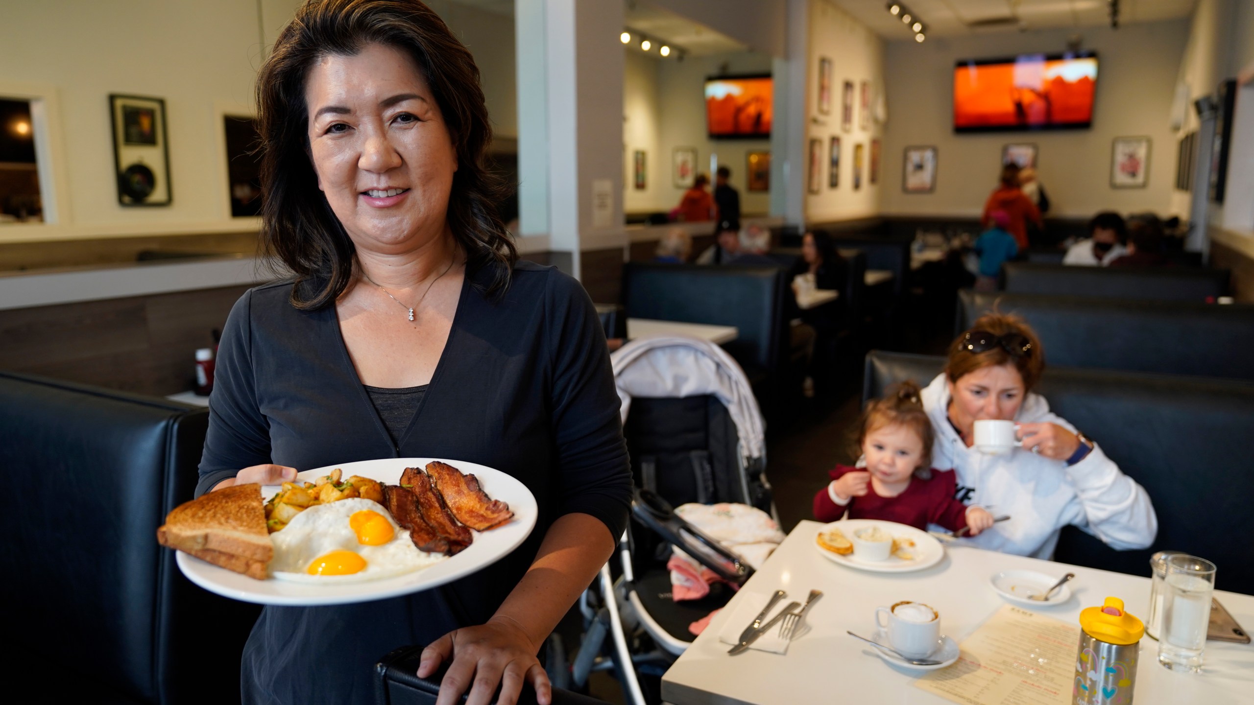 Jeannie Kim holds her popular bacon and eggs breakfast at her restaurant in San Francisco on Friday, July 30, 2021. Thanks to a reworked menu and long hours, Jeannie Kim managed to keep her San Francisco restaurant alive during the coronavirus pandemic. That makes it all the more frustrating that she fears her breakfast-focused diner could be ruined within months by new rules that could make one of her top menu items — bacon — hard to get in California. (AP Photo/Eric Risberg)