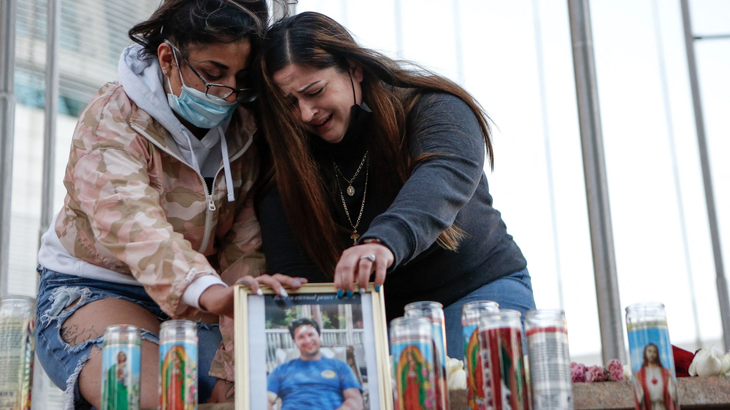 Two women mourn their cousin as they attend a vigil for the victims of a shooting at San Jose City Hall on May 27, 2021. (AMY OSBORNE/AFP via Getty Images)