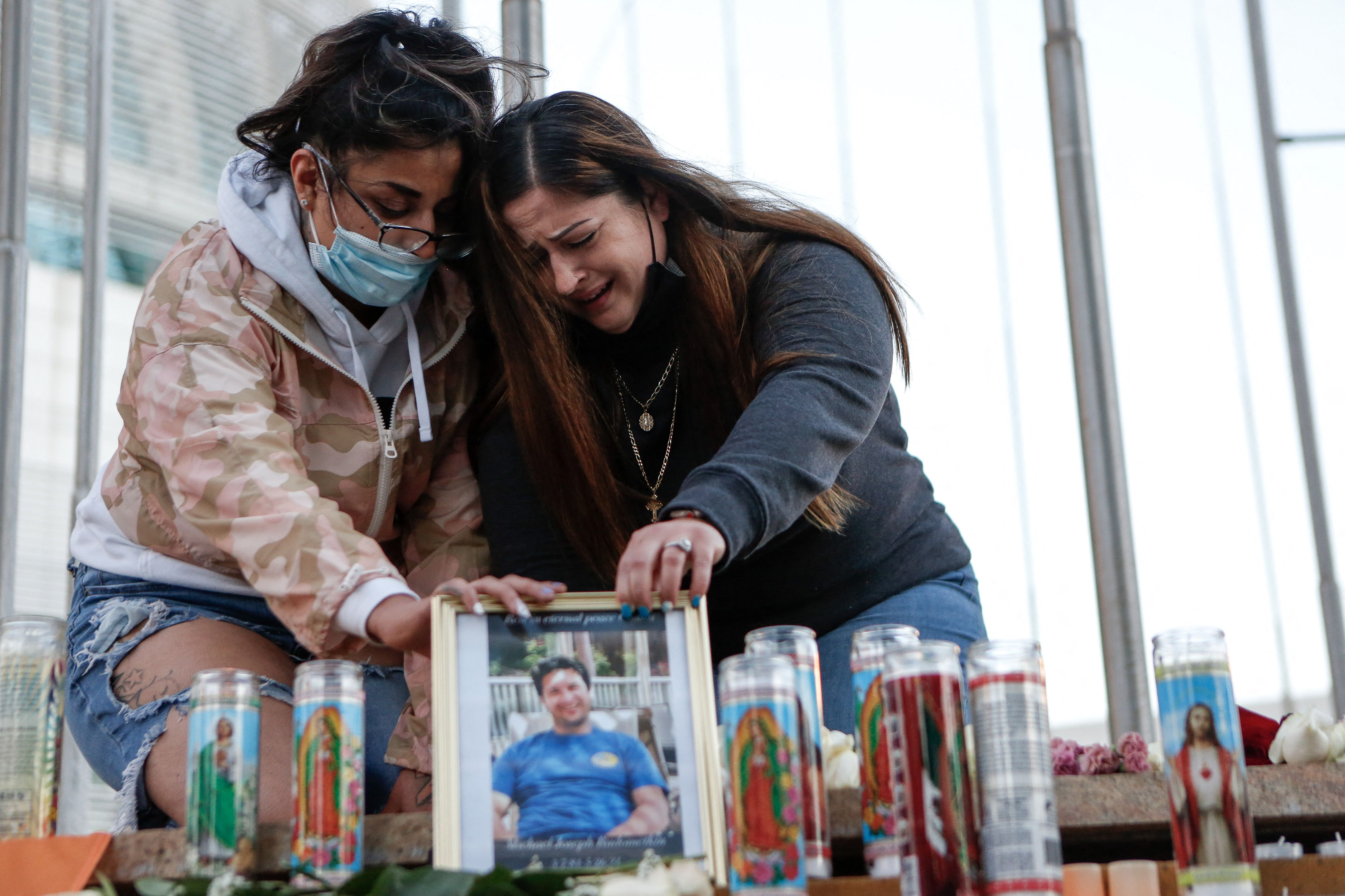 Two women mourn their cousin as they attend a vigil for the victims of a shooting at San Jose City Hall on May 27, 2021. (AMY OSBORNE/AFP via Getty Images)