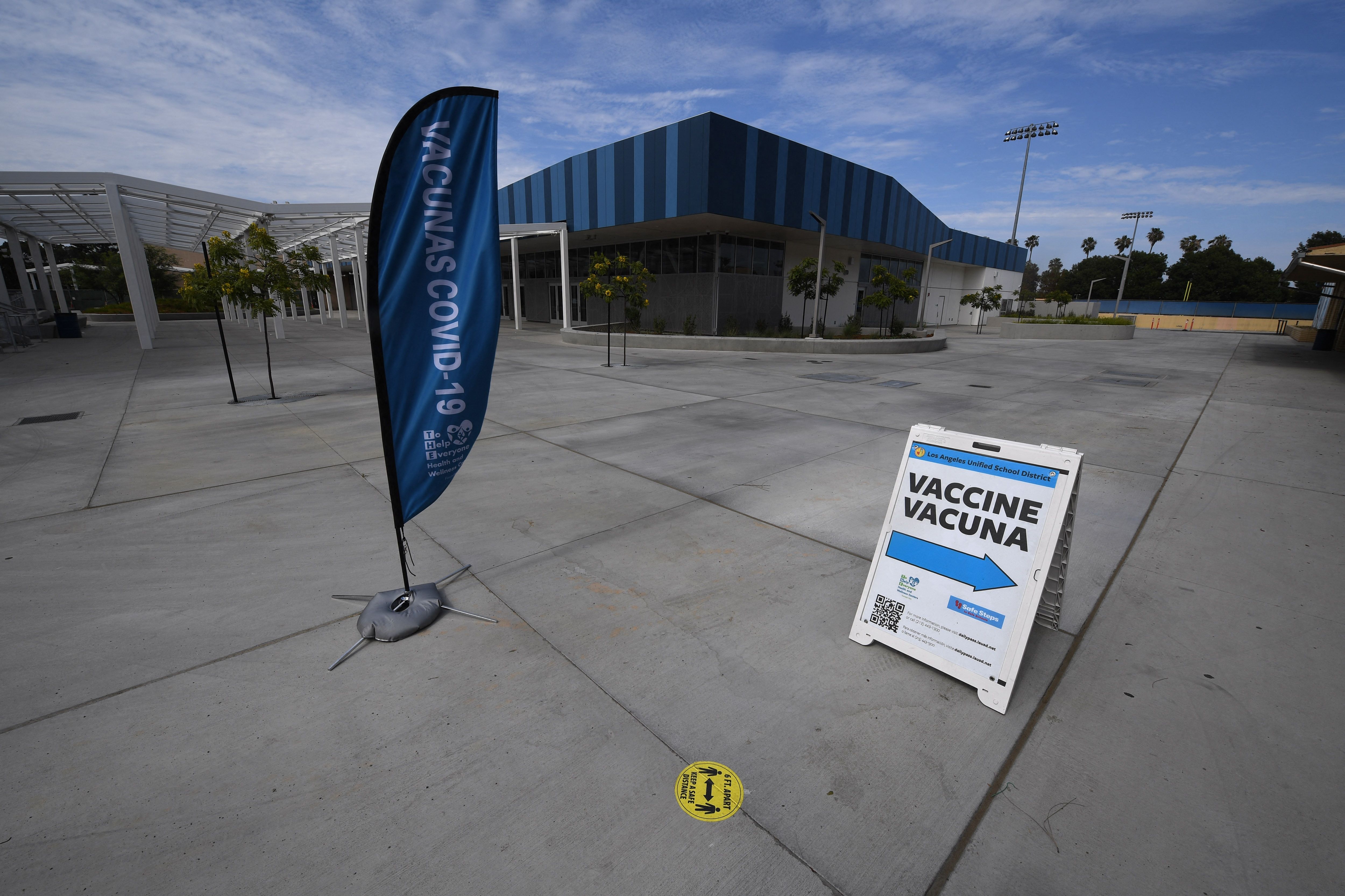 A sign points to a Covid-19 vaccination clinic offering the Pfizer vaccine to anyone over the age of 12 who wants it at Crenshaw High School in South Los Angeles, on July 8, 2021. The clinic was empty except for the staff working there. (ROBYN BECK/AFP via Getty Images)