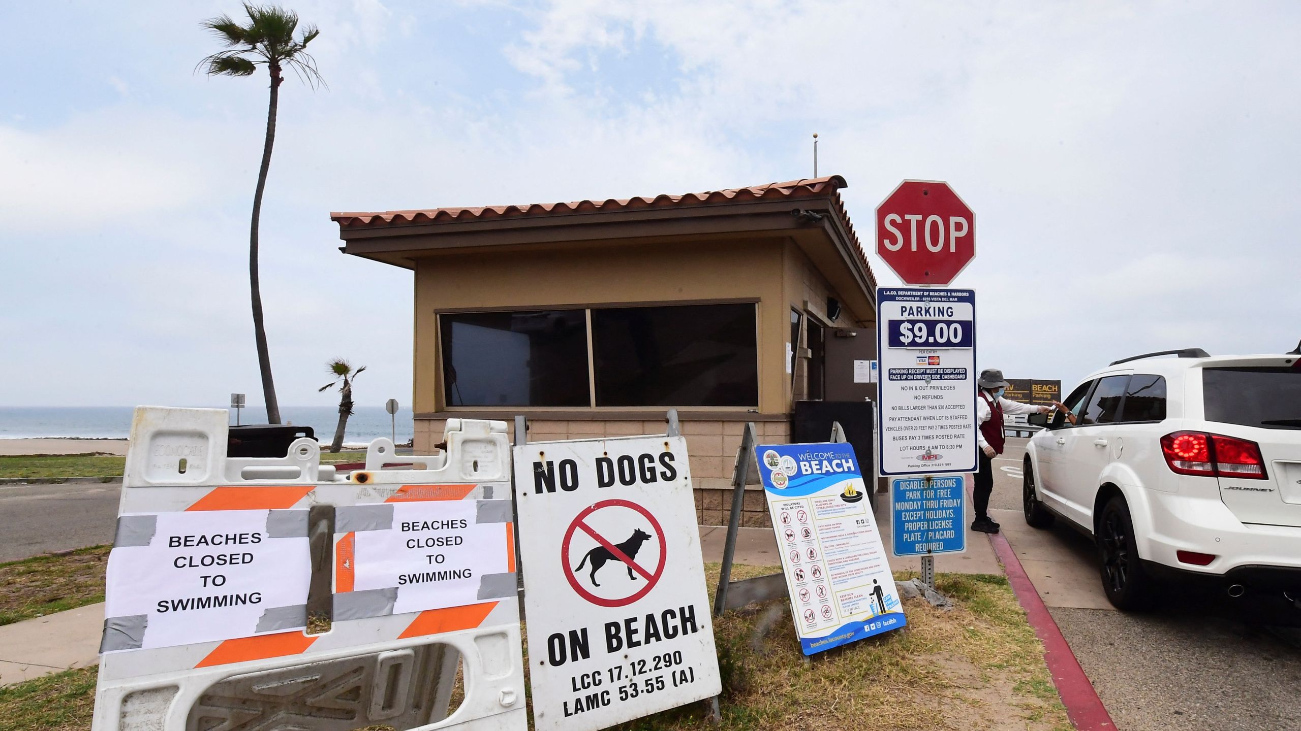 Signs posted at the entrance to Dockweiler State Beach indicate that the beach is closed to swimming after a sewage spill in Playa del Rey, in Los Angeles County, California, on July 13, 2021. (Frederic J. Brown/AFP via Getty Images)