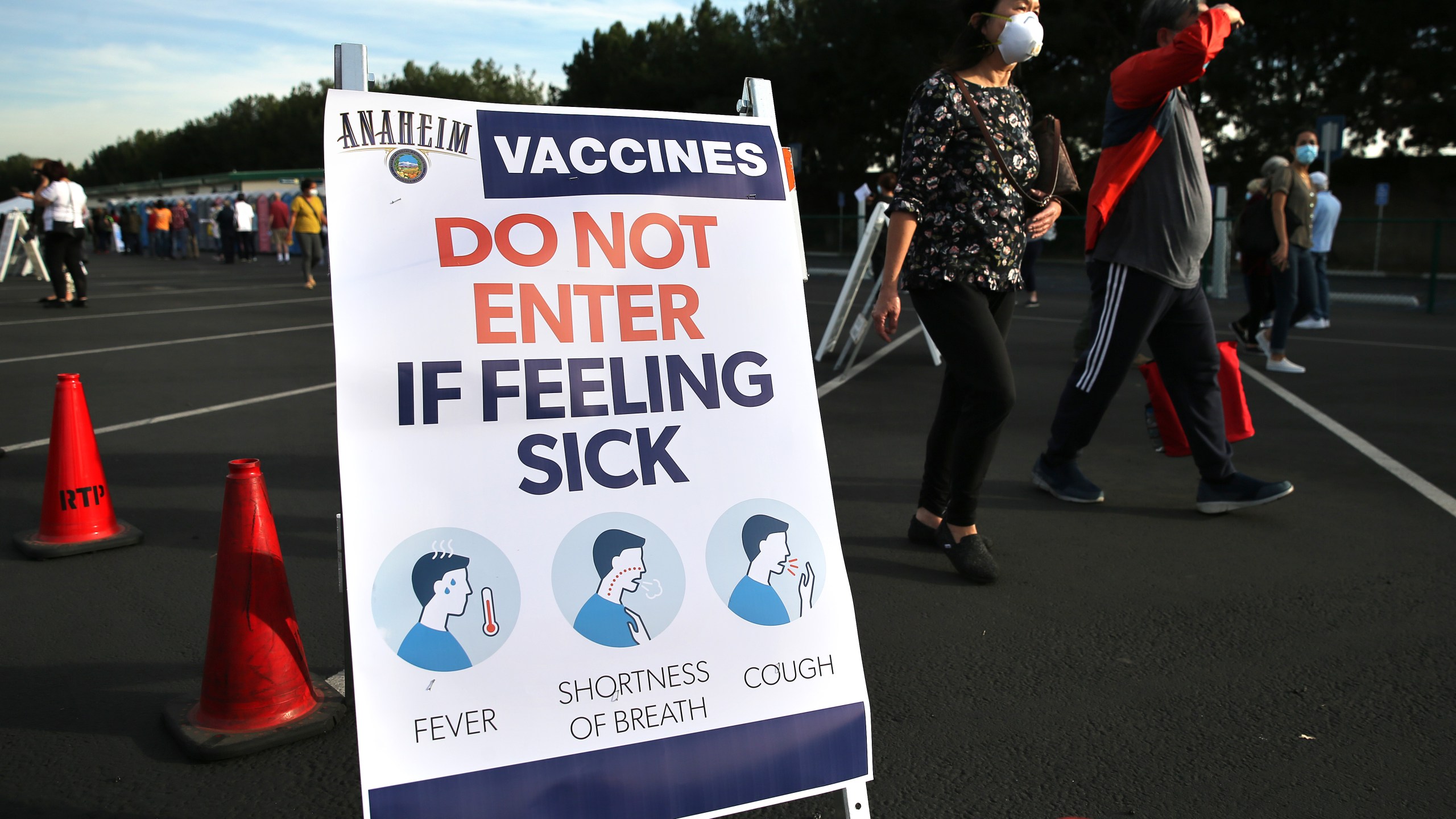 People walk at a mass COVID-19 vaccination site in a parking lot for Disneyland Resort on Jan. 13, 2021 in Anaheim. (Mario Tama/Getty Images)