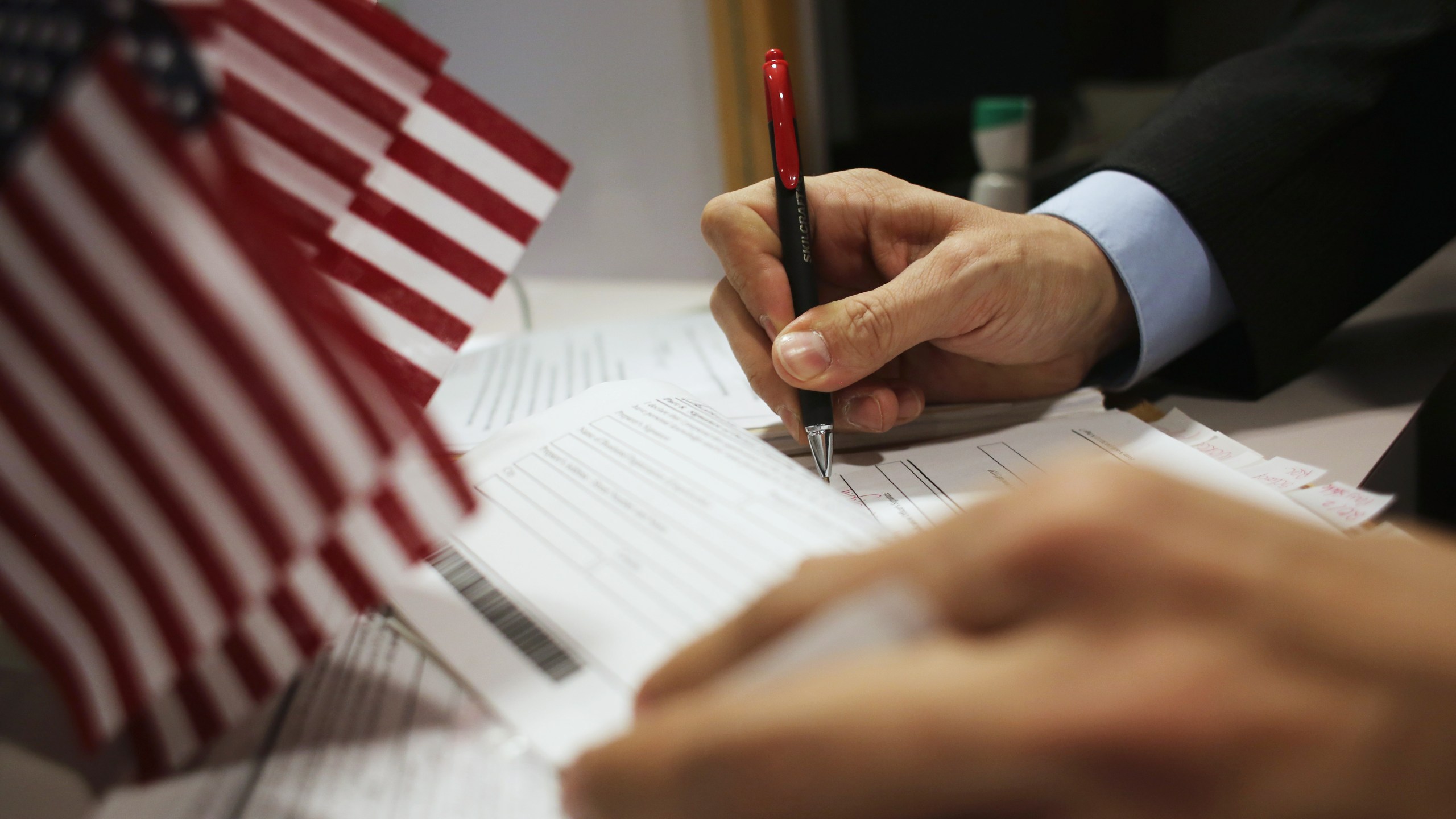 This file photo shows an official signing applications at the U.S. Citizenship and Immigration Services district office on Jan. 29, 2013, in New York City. (John Moore/Getty Images)